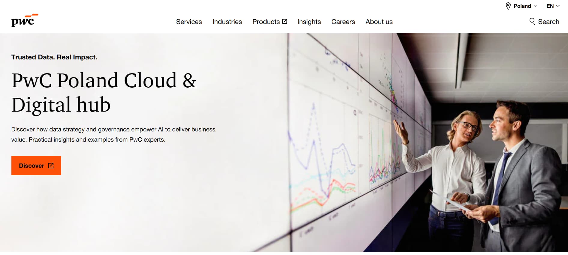 Consultants reviewing data charts on large screen in modern office.